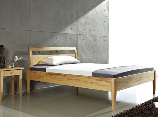 Massivholzbett in einem eingerichteten Schlafzimmer mit grauen Akzenten