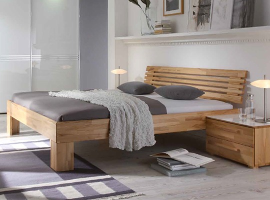 Massivholzbett in einem eingerichteten Schlafzimmer mit grauen Akzenten