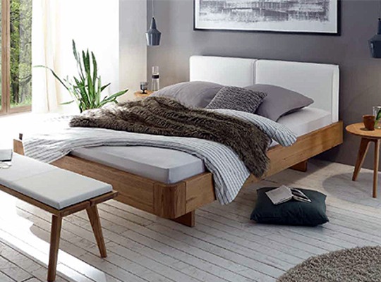 Massivholzbett in einem eingerichteten Schlafzimmer mit grauen Akzenten