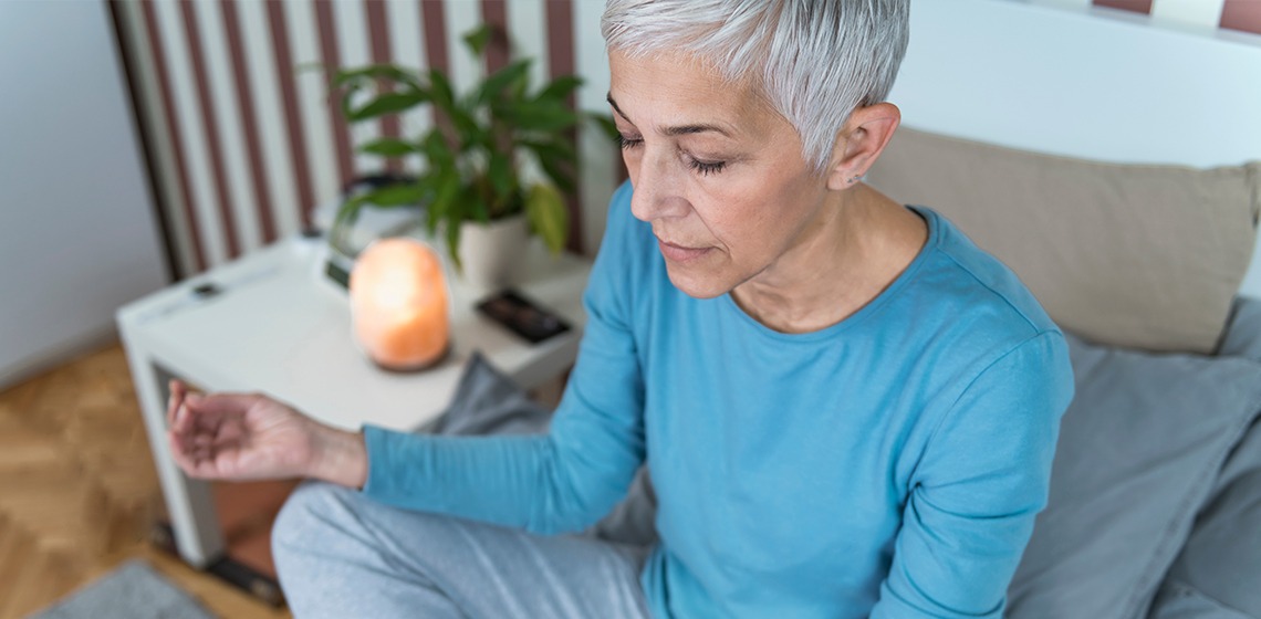 Eine Frau die auf einem Schlafsofa meditiert